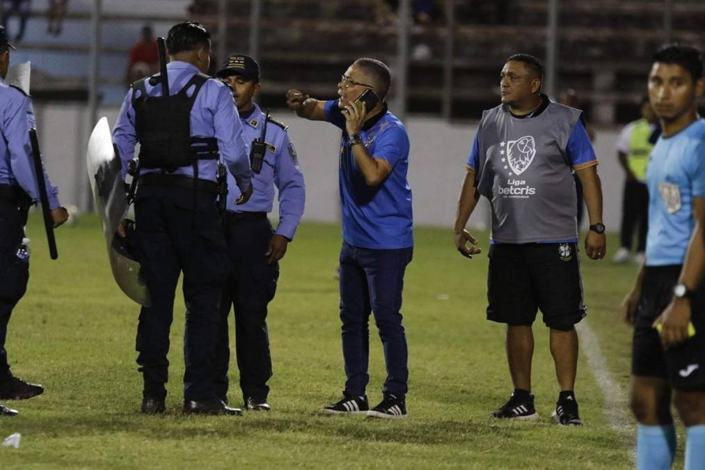 Miembros del Platense charlan con elementos de la Policía Nacional luego de que el partido se detuviera por minutos.