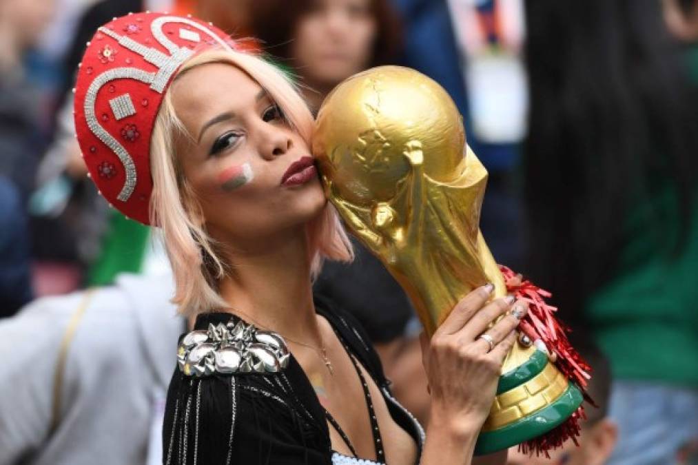 Una rusa besa una replica de la copa de la Fifa. AFP