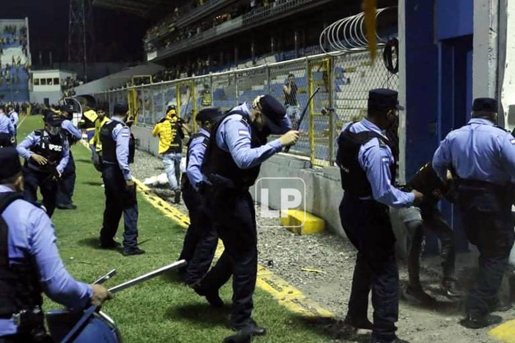 Los policías también tuvieron que resguardarse de la violencia de los aficionados.