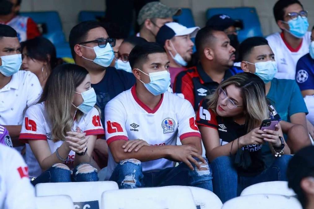 Este joven olimpista entre dos guapas aficionadas del Olimpia. ¡Qué afortunado!