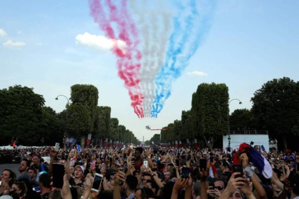 Mientras el autobús descubierto de dos pisos avanzaba lentamente hacia el Palacio del Elíseo, la escuadrilla acrobática de la fuerza aérea sobrevoló la emblemática avenida parisina formando con sus fumígenos la bandera tricolor roja, blanca y azul.