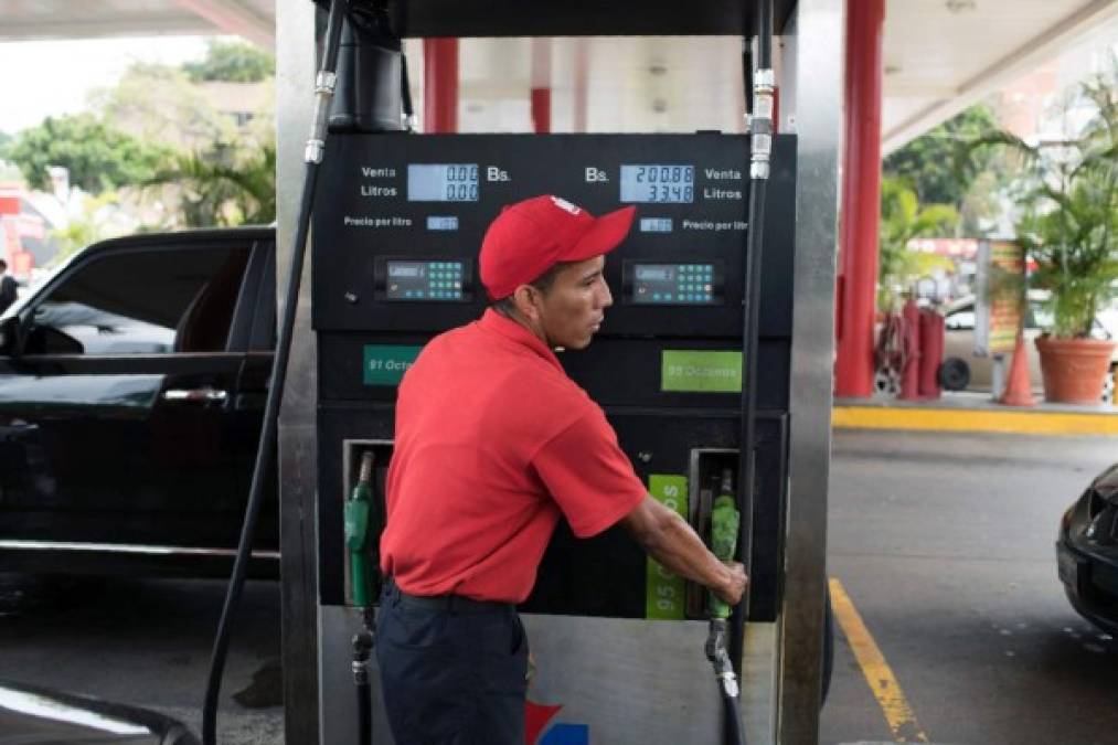 An employee works at a gas station in Caracas, on March 23, 2017. <br/>Concerned motorists await in long lines to refuel at gas stations across Venezuela, as a failure in distribution is affecting fuel supply. / AFP PHOTO / CARLOS BECERRA