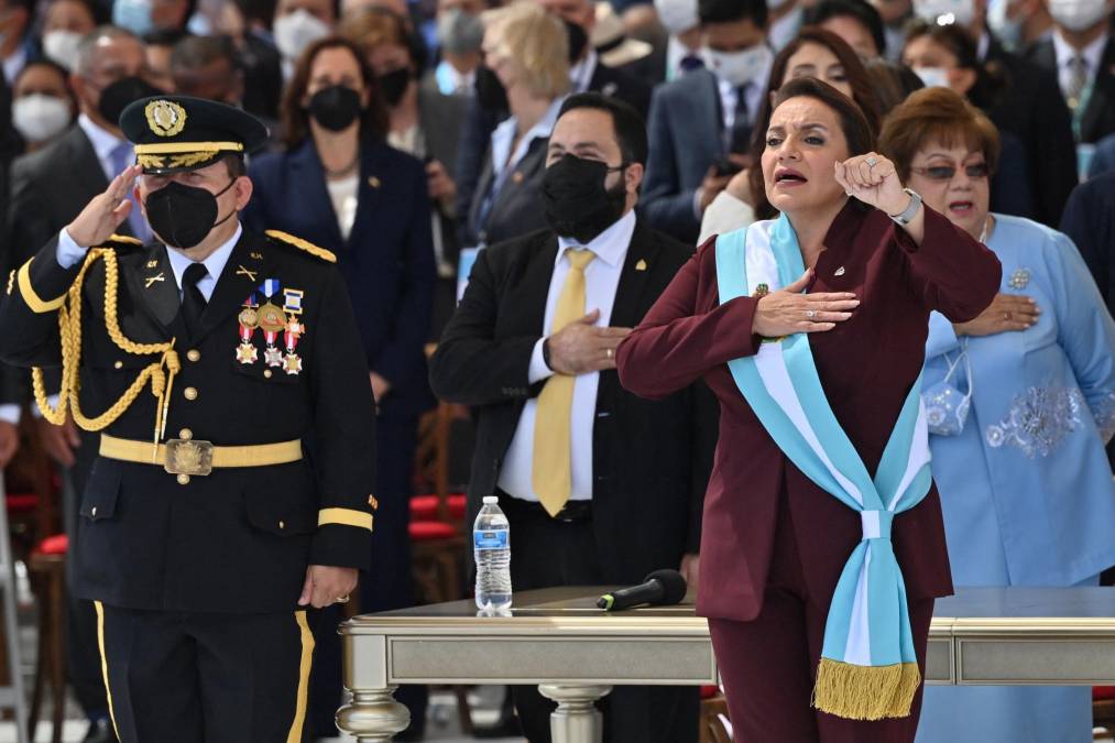 Honduran president-elect Xiomara Castro holds up her clenched fist as she wears the presidential sash after swearing in during her inauguration ceremony, in Tegucigalpa, on January 27, 2022. - Honduras president-elect Xiomara Castro swore in as the country's first woman president on Thursday, as confusion reigns over who will be head of congress during her four-year term. (Photo by Luis Acosta / AFP)