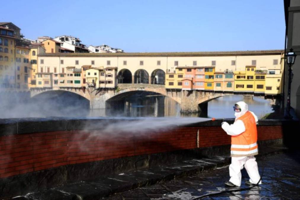 Un trabajador desinfecta un muro cerca de Ponte Vecchio, emblema de Florencia, Italia. <br/><br/><br/><br/><a href='https://www.laprensa.hn/especiales/coronavirus/1365644-410/hondure%C3%B1a-relata-italia-coronavirus-todo-descontrolo-rapidamente' style='color:red;text-decoration:underline' target='_blank'>Toca para leer la entrevista completa con Karen Canela</a>