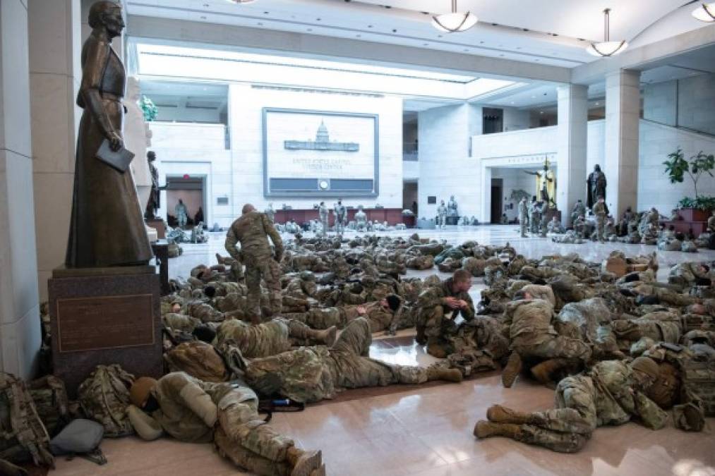 Miembros de la Guardia Nacional descansan en los pasillos del Congreso mientras se discute una sesión para iniciar juicio político, por segunda vez, al presidente saliente Donald Trump. FOTO AFP