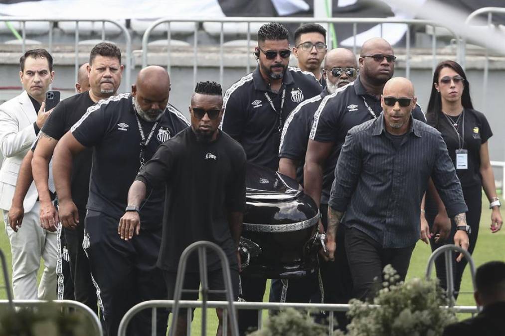 El hijo de Pelé Edinho (frente d), el exfutbolista Zé Roberto (frente i) y amigos del Edson Arantes do Nascimento fueron los encargados de llevar el ataúd de la leyenda del fútbol mundial.