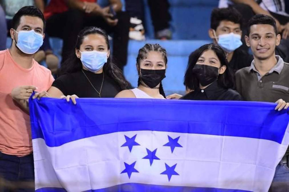 Un grupo de aficionados posando con la bandera de Honduras.