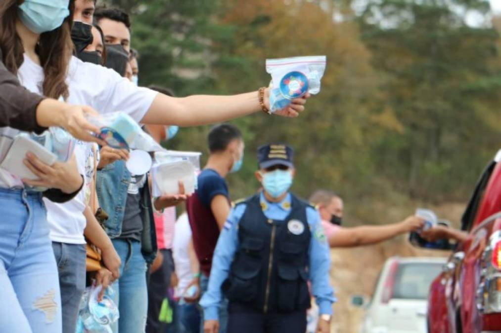 Voluntarios de Conapremm y organizaciones sociales entregan insumos de bioseguridad a familias hondureñas. A pesar de la crisis económica, miles viajaron a centros turísticos.