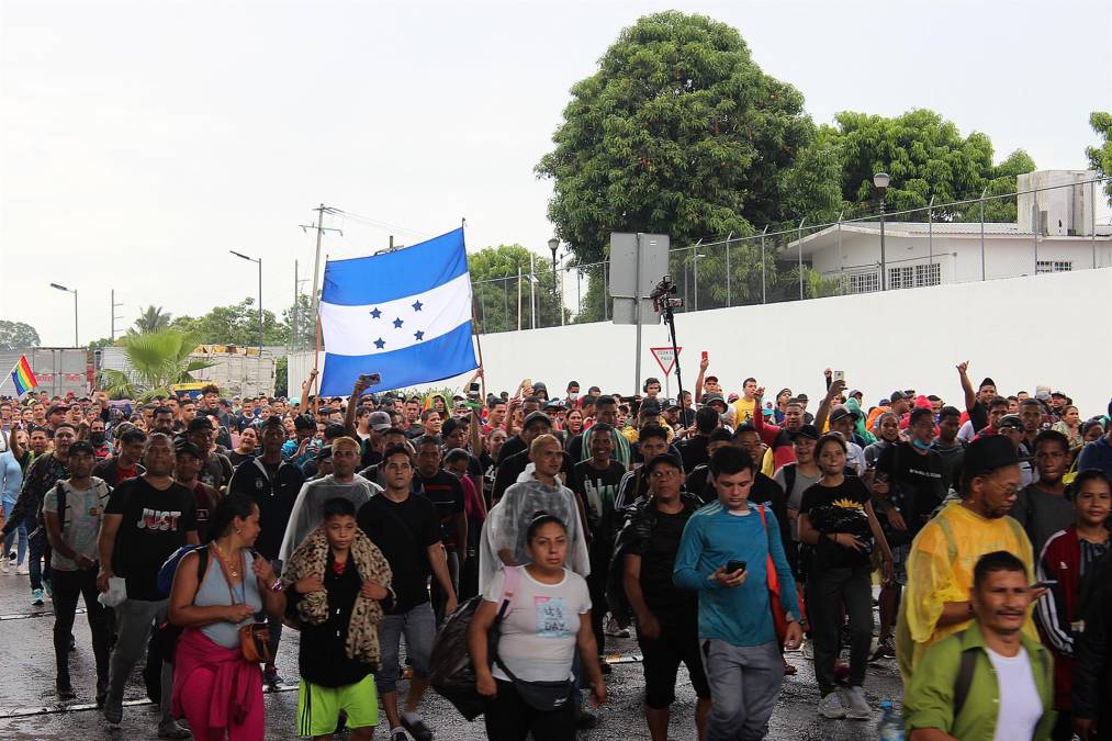 Los migrantes se cubrieron con paraguas, cartones, bolsas, impermeables y toallas para protegerse de la lluvia en su viaje hacia EEUU.