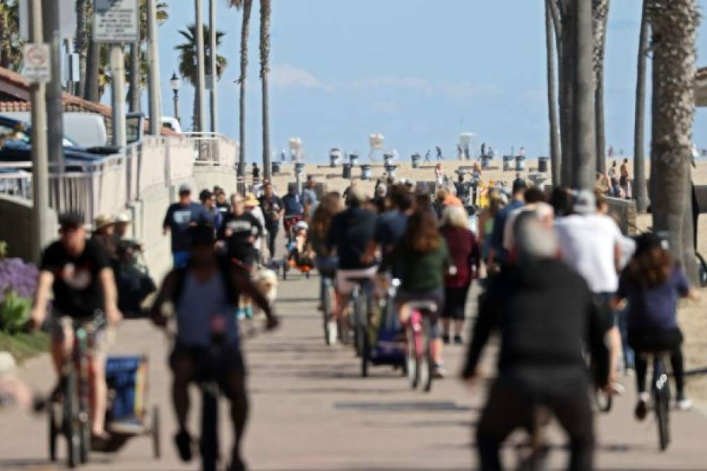 HUNTINGTON BEACH, - MARCH 21: People ride their bikes along a bike bath near the pier on March 21, 2020 in Huntington Beach, California. California Governor Gavin Newsom issued a statewide stay at home order for Californias 40 million residents except for necessary activities in the hopes of slowing the spread of coronavirus (COVID-19). Michael Heiman/Getty Images/AFP