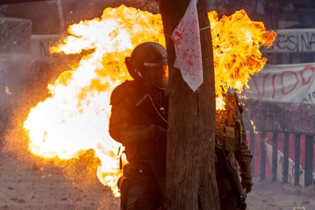 Las dramáticas imágenes de las carabineras en llamas fueron captadas por los fotógrafos que cubrían las violentas protestas en la capital chilena.