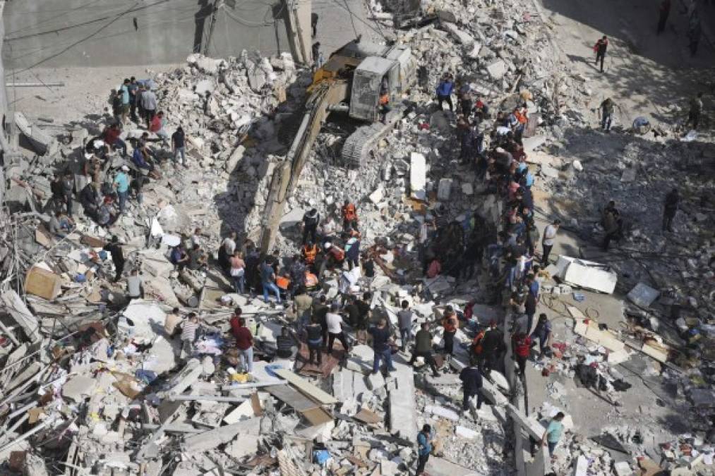 Los palestinos buscan víctimas bajo los escombros de un edificio destruido en el distrito residencial Rimal de la ciudad de Gaza el 16 de mayo de 2021, luego del bombardeo masivo israelí en el enclave controlado por Hamas. (Foto de Mahmud hams / AFP)