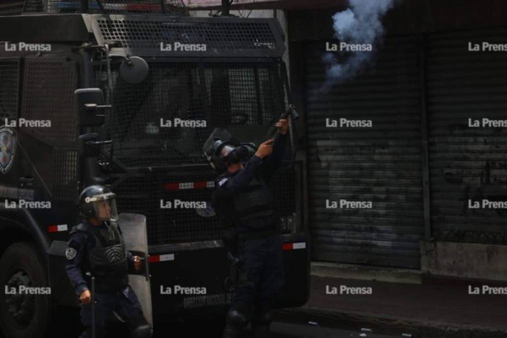 Un agente de la Policía Nacional de Honduras lanza una bomba lacrimógena a la multitud. Hubo niños, embarazadas y ancianos que resultaron afectados.