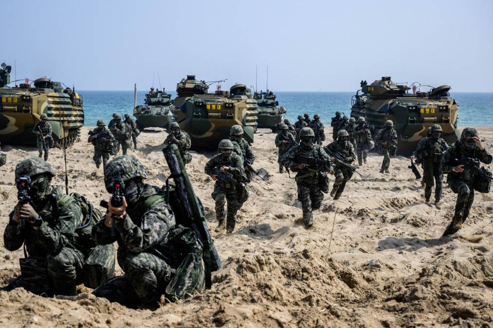 Al avanzar por la playa se escuchan consignas a través de un megáfono; es un grupo de surcoreanos animando a las tropas de ambos países y congratulándose de que estos ejercicios vuelvan a celebrarse por primera vez desde 2018.