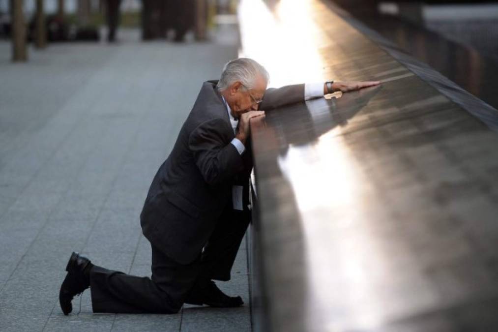 Un padre llora al encontrar el nombre de su hijo en el memorial de Nueva York.
