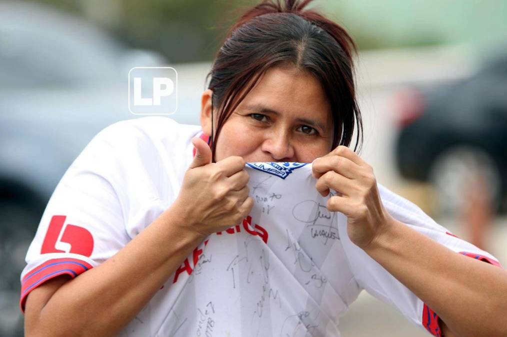 Una aficionada del Olimpia besando el escudo del campeón de la Liga Concacaf.