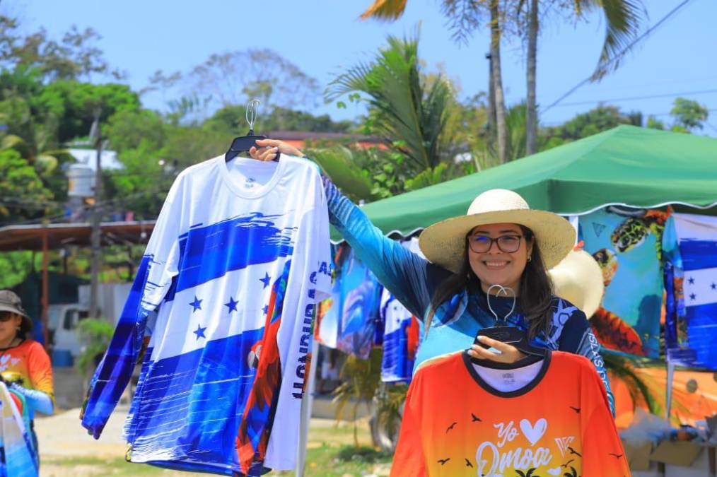 Una hondureña vende camisas alusivas a la bandera nacional en las bellas playas de Omoa. 