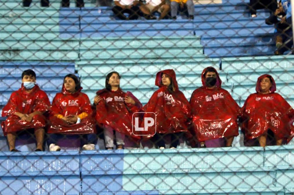 Algunos aficionados se protegieron por la lluvia en la capital.