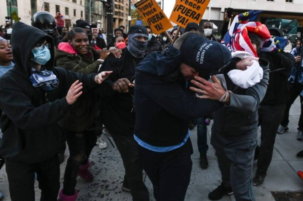 A supporter of US President Donald Trump is attacked by anti-Trump demonstrators in Black Lives Matter Plaza in Washington, DC on November 14, 2020. (Photo by Roberto SCHMIDT / AFP)