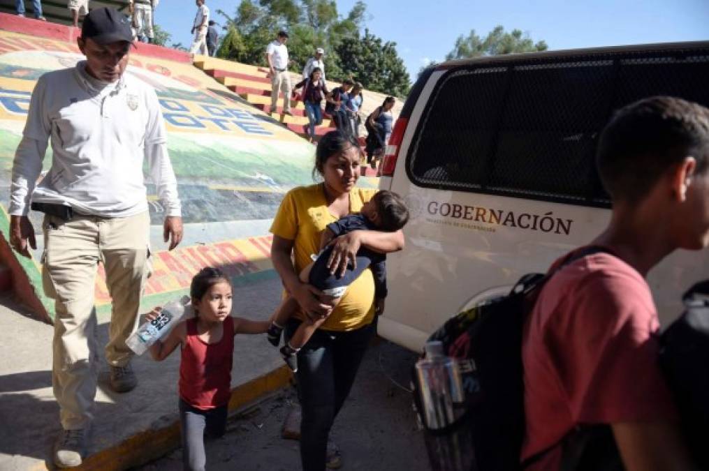 Members of the National Guard and officers of the Migration Institute detain a Central American migrant family in Ciudad Hidalgo, Chiapas State, Mexico, on January 21, 2020, after they crossed the Suichate River, the natural border with Tecum Uman in Guatemala. - The Mexican government tried to dialogue with the new caravan of Central Americans on Tuesday to prevent their irregularly entering and instead take a refuge and temporary employment programs in the south of the country. (Photo by ALFREDO ESTRELLA / AFP)