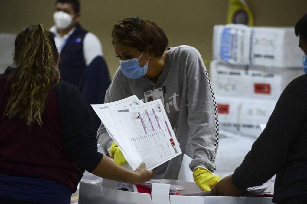 Funcionarios del CNE realizan el escrutinio de las actas en el centro de cómputo del CNE. Tres partidos políticos participaron en el proceso electoral: Liberal, Nacional y Libre. Foto: AFP