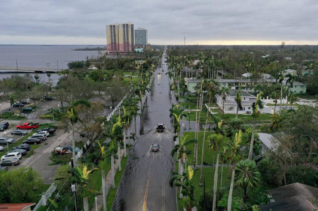 En esta vista aérea, los vehículos atraviesan un área inundada después de que el huracán Ian pasara por el área el 29 de septiembre de 2022 en Fort Myers, Florida. El huracán trajo fuertes vientos, marejadas ciclónicas y lluvias al área causando daños severos. 