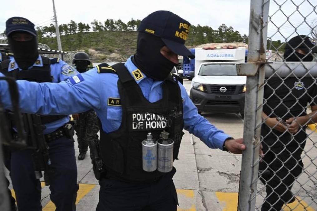Oficiales de Policía Nacional resguardan el portón de acceso a 'La Tolva'. Familiares de los reos intentaron forzar la entrada para ingresar.
