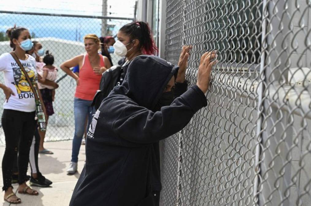 A woman waits outside the La Tolva National Prison to know the identity of the injured prisoners, in Moroceli, Honduras, on June 17, 2021. - At least 12 inmates were injured after a gang conflict between Pandilla 18 and Mara Salvatrucha MS-13, inside the La Tolva maximum security prison. (Photo by Orlando SIERRA / AFP)