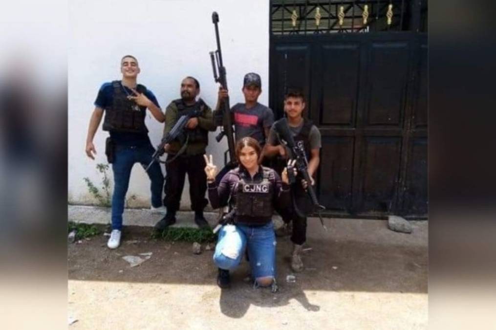 La Guadaña posando con armamento y chaleco antibalas del CJNG. La acompañan otros sicarios de El Mencho.