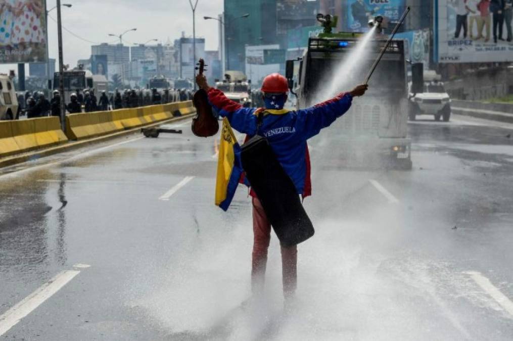 Armado con su violín, el manifestante Wuilly Arteaga le hace frente a las fuerza de seguridad.