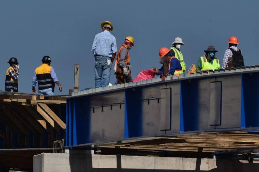 Workers at the construction site of a bridge in Tegucigalpa on June 8, 2020, after the governmet announced the resumption of economic activity, amid the COVID-19 pandemic. - Honduras reopens its business activities, cautiously, after almost three months of confinement, though, according to experts, at the worst time to do so due to the rapid rise of the coronavirus and at high risk of closing again. (Photo by ORLANDO SIERRA / AFP)