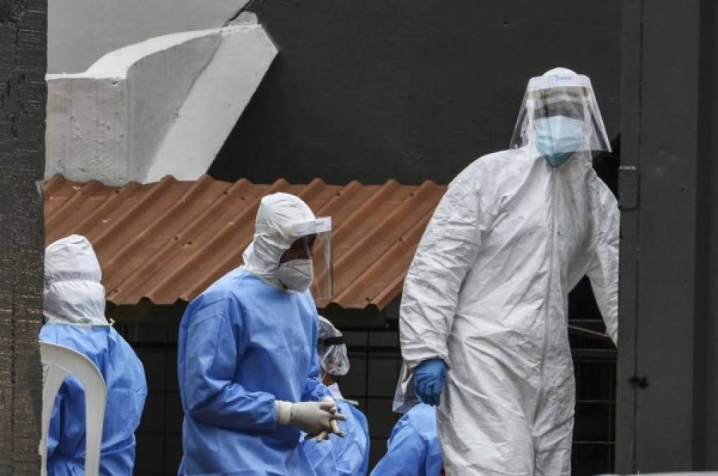 Personal de la Secretaría de Salud son vistos en las afueras del centro de triaje en el Infop, esta mañana en Tegucigalpa. Foto: AFP