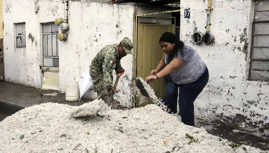 Soldados del Ejército Mexicano retiran granizo de las calles el viernes en Puebla.
