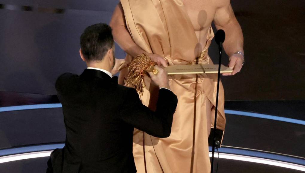 Lo que no se vio en las cámaras de televisión fue cuando miembros del staff subieron al escenario para vestir con una capa a John Cena, por mientras en la pantalla gigante transmitían los videos de los nominados. Kimmel fue el último en amarrar el lazo del improvisado vestuario.