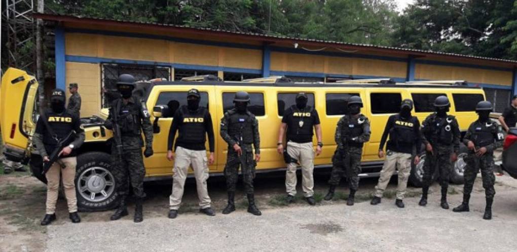 This handout photo released by the Technical Criminal Investigation Agency (ATIC) of Honduras shows members of that agency and military police guarding a limousine confiscated from druglords who replaced the leaders of the Los Cachiros cartel after they were extradited to the United States, in the city of Tocoa, department of Colon, to the northwest of Tegucigalpa, on June 21, 2017. <br/>In the 'Firestorm VI' operation, at least 24 properties were seized and arrest warrants were carried out against members of the 'Los Peludos' criminal organization. / AFP PHOTO / ATIC / HO / RESTRICTED TO EDITORIAL USE-MANDATORY CREDIT 'AFP PHOTO/AGENCIA TECNICA DE INVESTIGACION CRIMINAL DE HONDURAS' NO MARKETING NO ADVERTISING CAMPAIGNS-DISTRIBUTED AS A SERVICE TO CLIENTS-XGTY