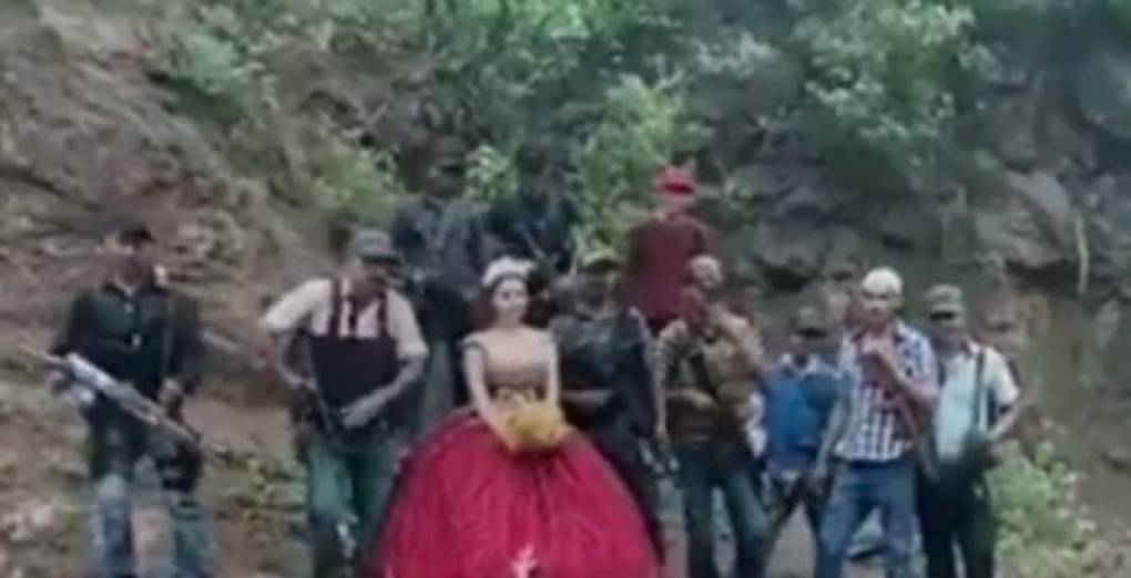 En el se observa a la feliz quinceañera mientras que varios hombres armados caminan para tomarse la tradicional foto de quinceaños.