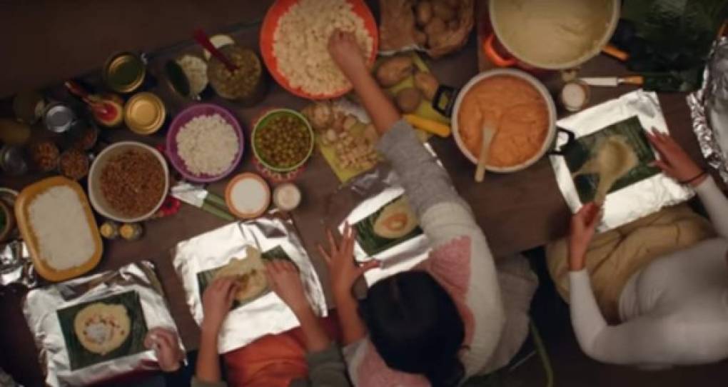 En el video se puede ver a un grupo de mujeres preparando tamales con varios ingredientes en una mesa.