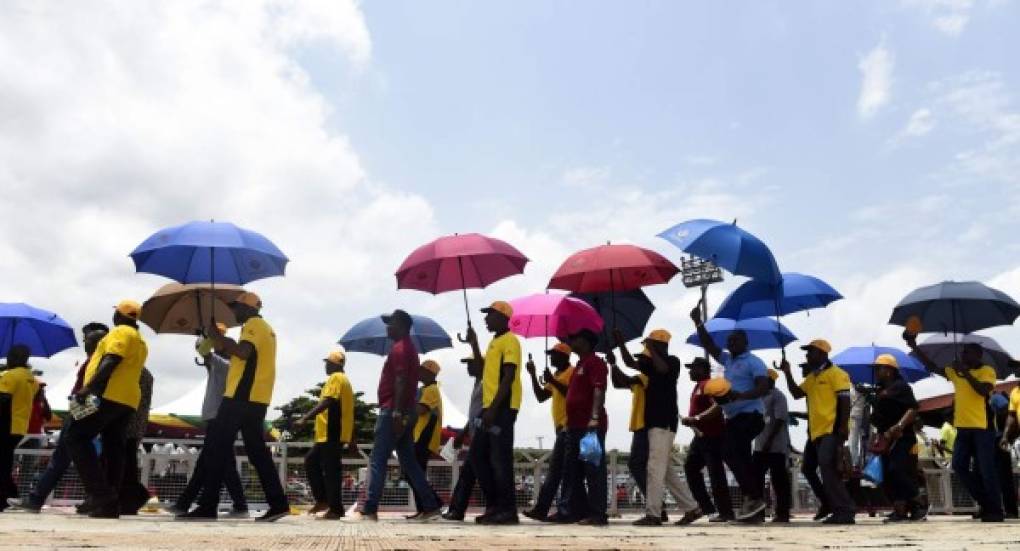 Manifestantes se protegen del fuerte sol africano durante una marcha en Lagos, Nigeria.