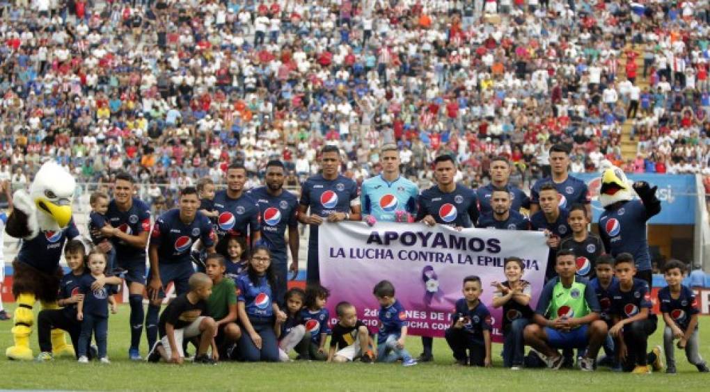 El once titular del Motagua posando con varios niños.