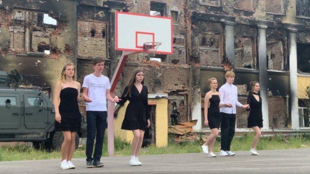 Desafiantes estudiantes ucranianos celebran su fiesta de graduación frente a las ruinas de su escuela