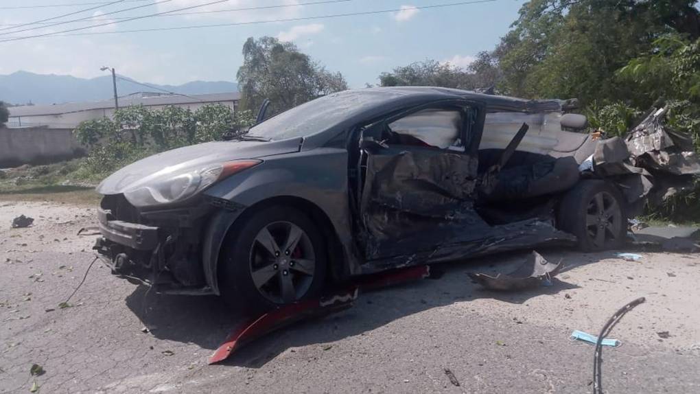 Uno de los carros turismo destruido por el impacto de la rastra.