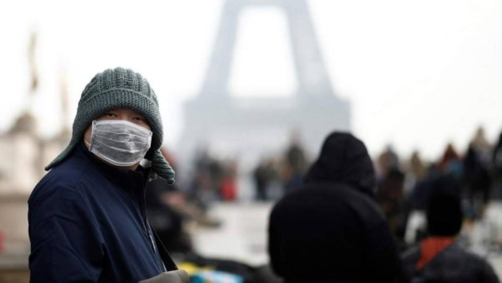 People wearing a protective facemasks walk with their groceries on a street in Beijing on January 30, 2020. - The World Health Organization, which initially downplayed the severity of a disease that has now killed 170 nationwide, warned all governments to be 'on alert' as it weighed whether to declare a global health emergency. (Photo by NICOLAS ASFOURI / AFP)