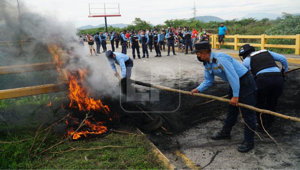 Los policías limpiaron el caucho quemado.