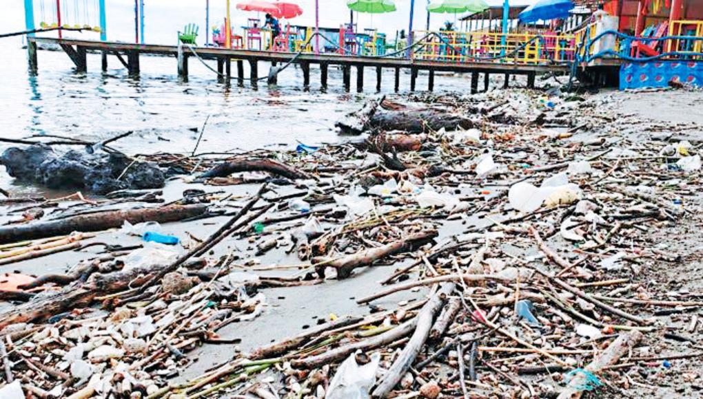 Rompimiento de biobarda provoca que playas de Omoa se llenen de basura