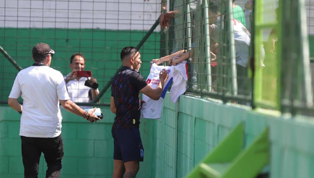 Kevin López firmando autógrafo en una camiseta del Olimpia.
