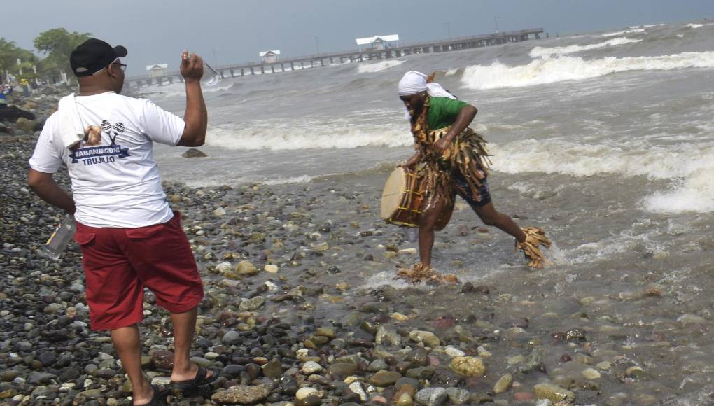 Dixon Miranda, en un ritual, esparce licor sobre uno de los dramatizadores, “para darle la apertura de los ancestro cuando van a llegar. Es algo solemne para nosotros, recordamos a nuestros fallecidos”, explicó.
