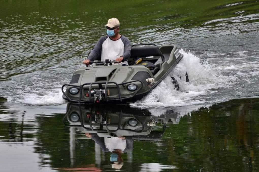 Un hombre viaja en un vehículo anfibio en el lago Yojoa. AFP