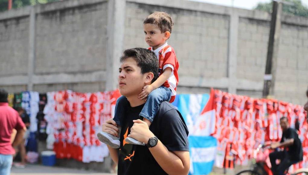 Un padre orgulloso cargando a su hijo con la camiseta del Vida.