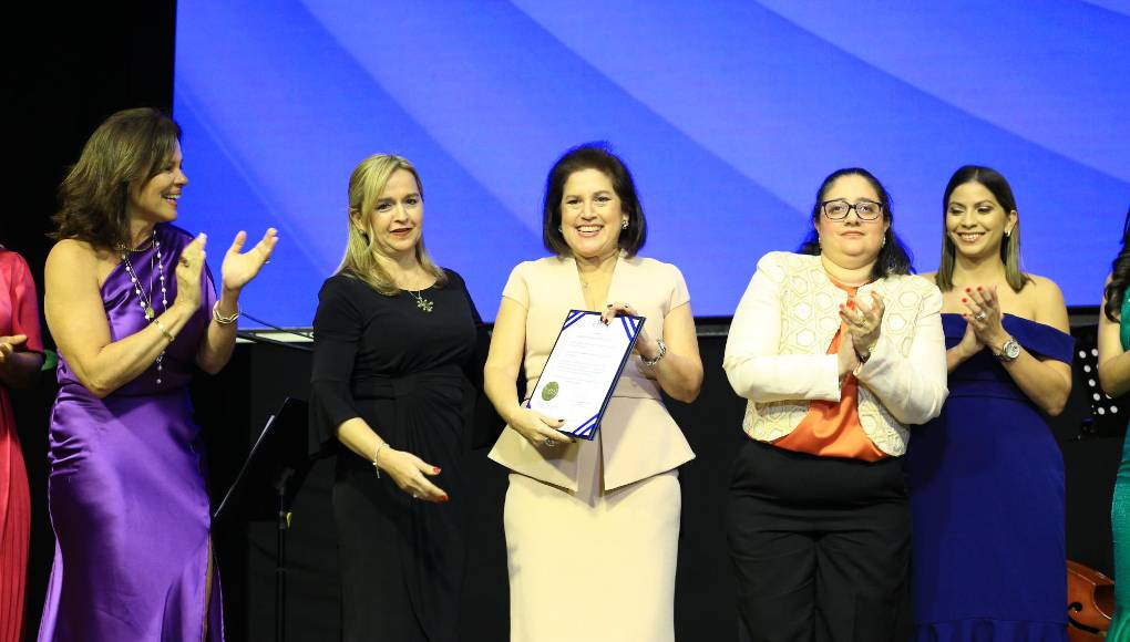 Ana Clemencia Bueso, gerente general de Laboratorio Bueso Arias, posando con el certificado de acreditación bajo la norma ISO 15189, mientras es aplaudida por conseguir este logro en conjunto de su directivos de la empresa, así como influyentes colaboradores que fueron parte fundamental de semejante conquista. 