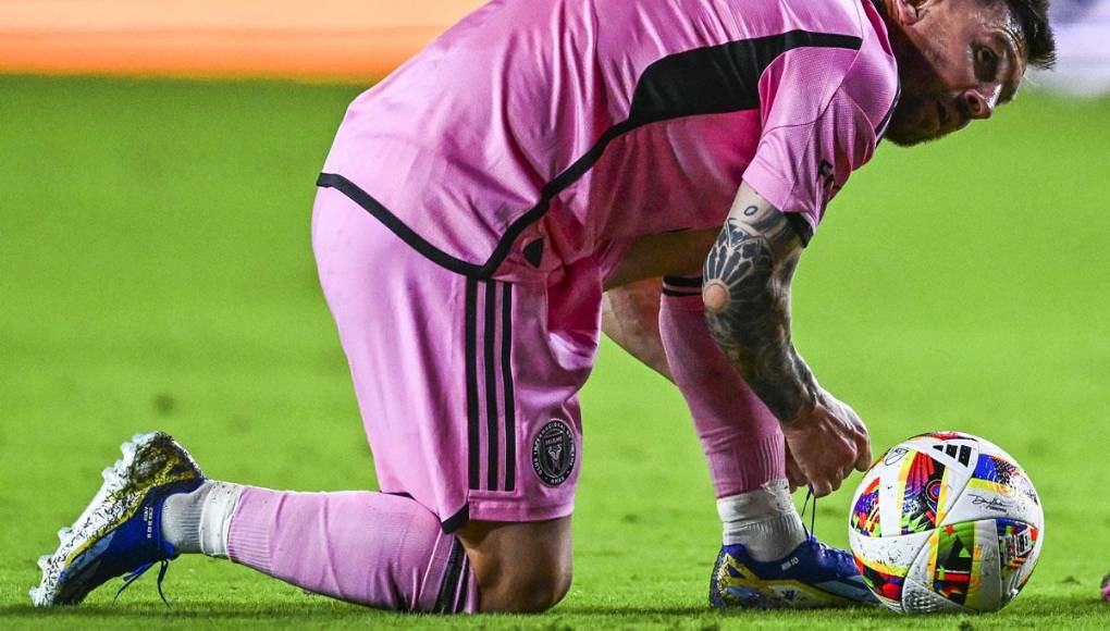 ’La Pulga’ se ata sus tacos antes de realizar un tiro libre directo buscando marcar gol.